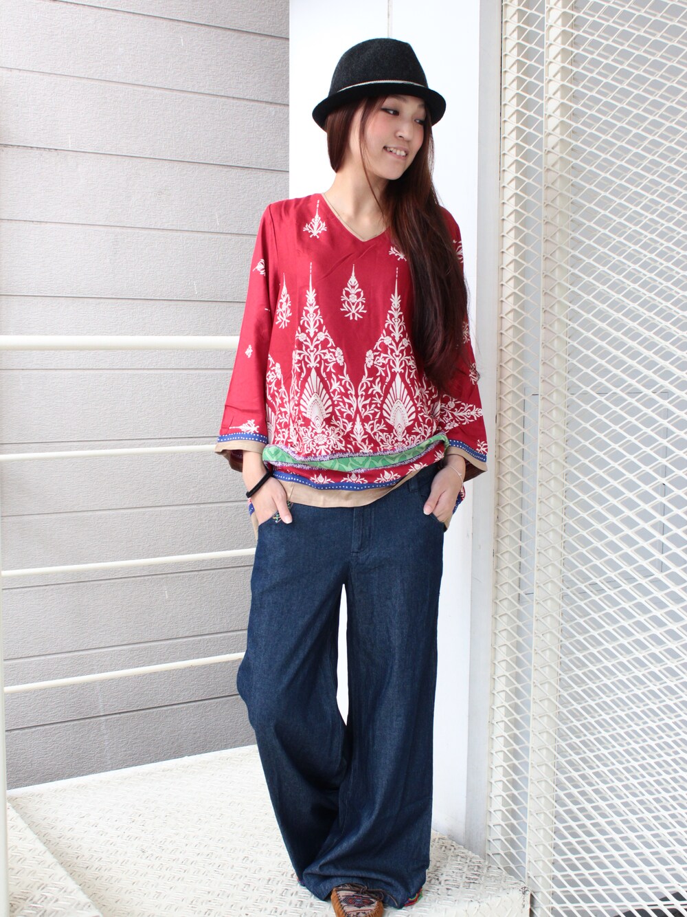 レッド系のシャツ/ブラウス、ブルー系のデニムパンツ、グレー系のハットを着用したレディースの冬コーディネートの1枚目の写真