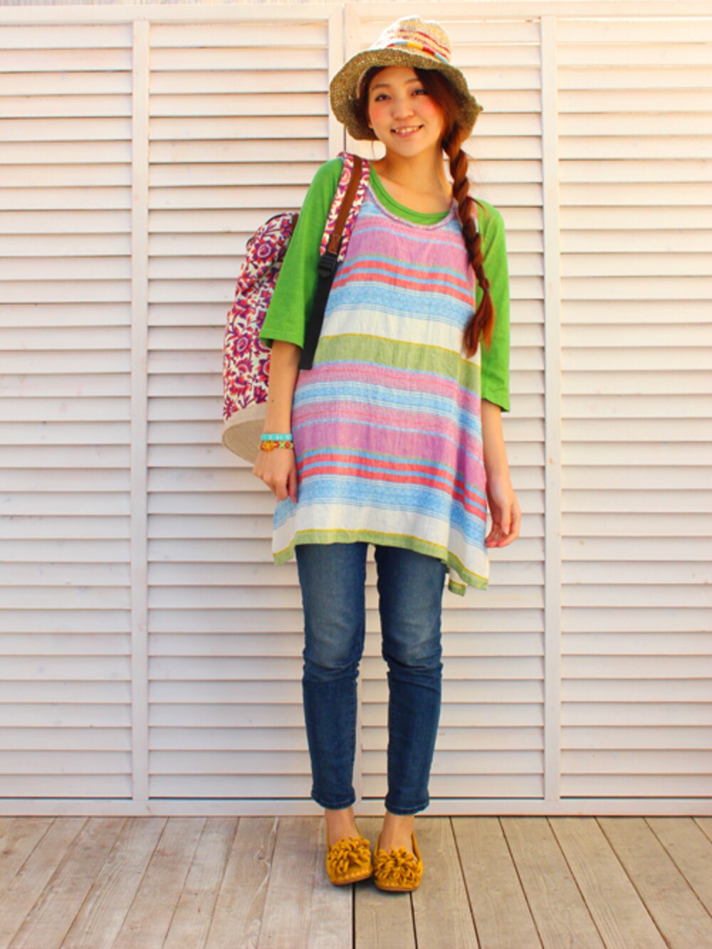 パープル系のチュニック、グリーン系のTシャツ/カットソー、ホワイト系のバックパック/リュックを着用したレディースの春コーディネートの1枚目の写真