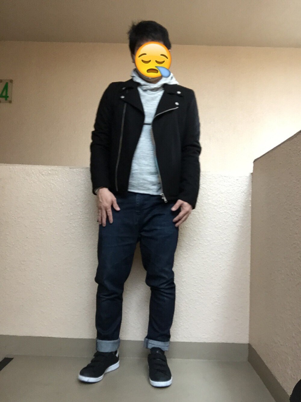 ブラック系のピーコート、グレー系のパーカー、ブルー系のデニムパンツを着用したメンズの春コーディネートの1枚目の写真