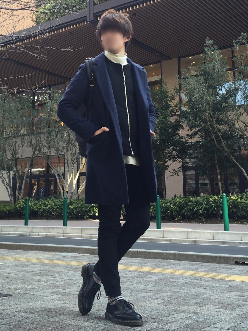 ブラック系のブルゾン、ブルー系のチェスターコート、ホワイト系のニット/セーターを着用したメンズの冬コーディネートの1枚目の写真