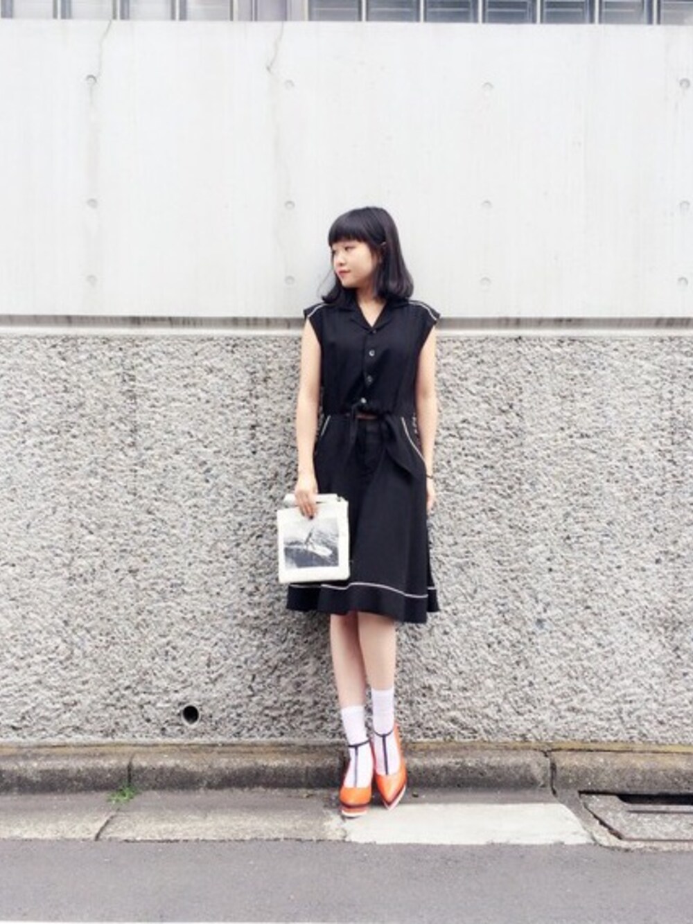 「g.v.g.v.、ワンピース、パンプス、オレンジ、クラッチバッグ」｜「G.V.G.V.のTENCEL FRONT KNOT SKATER DRESS（ワンピース、ブラック系）」を使った、Nao Shinmuraさん（レディース・156cm）の春コーディネートの1枚目の写真