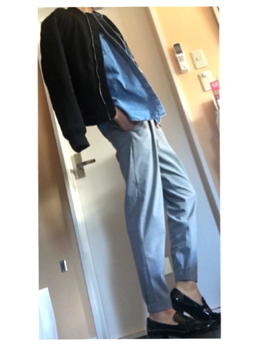 ブラック系のミリタリージャケット、ブルー系のシャツ/ブラウス、グレー系のパンツを着用したレディースの春コーディネートの1枚目の写真