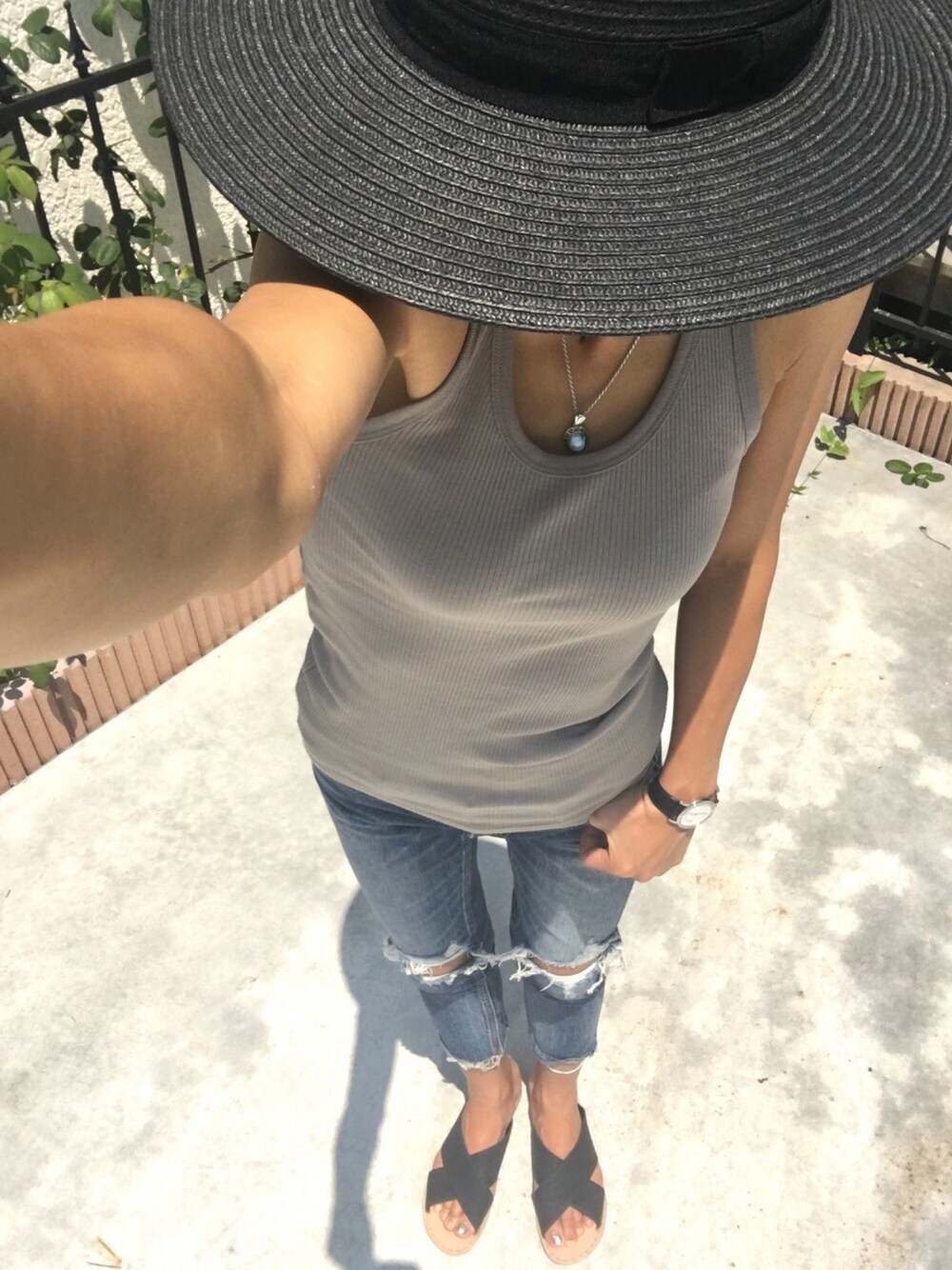 ベージュ系のタンクトップ、ブルー系のデニムパンツ、ブラック系のサンダルを着用したレディースの夏コーディネートの1枚目の写真