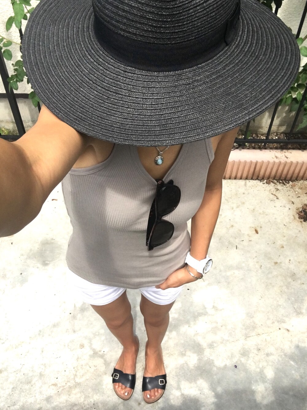 ベージュ系のタンクトップ、ホワイト系のデニムパンツ、ブラック系のサンダルを着用したレディースの夏コーディネートの1枚目の写真