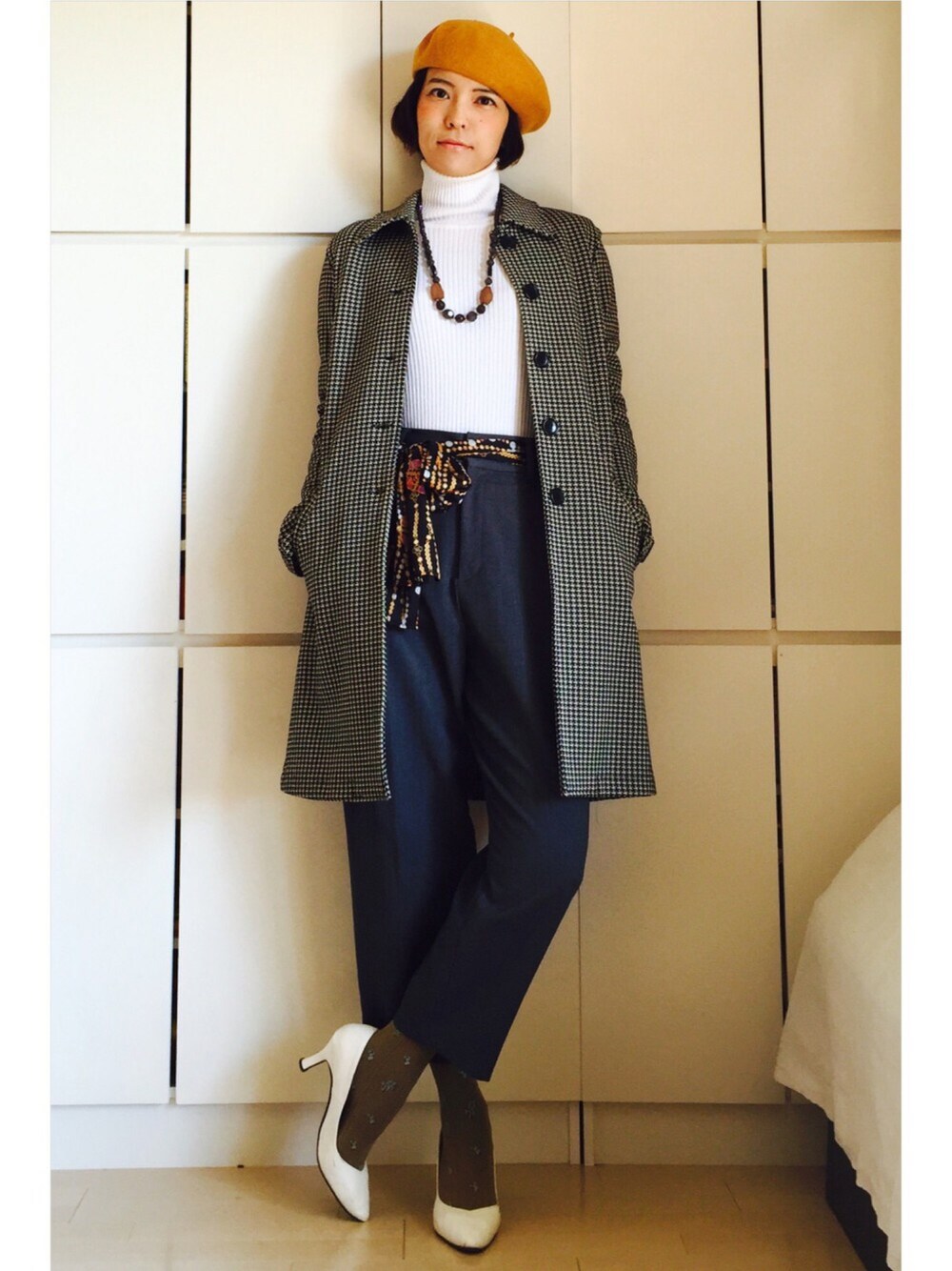 グレー系のスラックス、ブラック系のジャケット/アウター、ホワイト系のニット/セーターを着用したレディースの春コーディネートの1枚目の写真