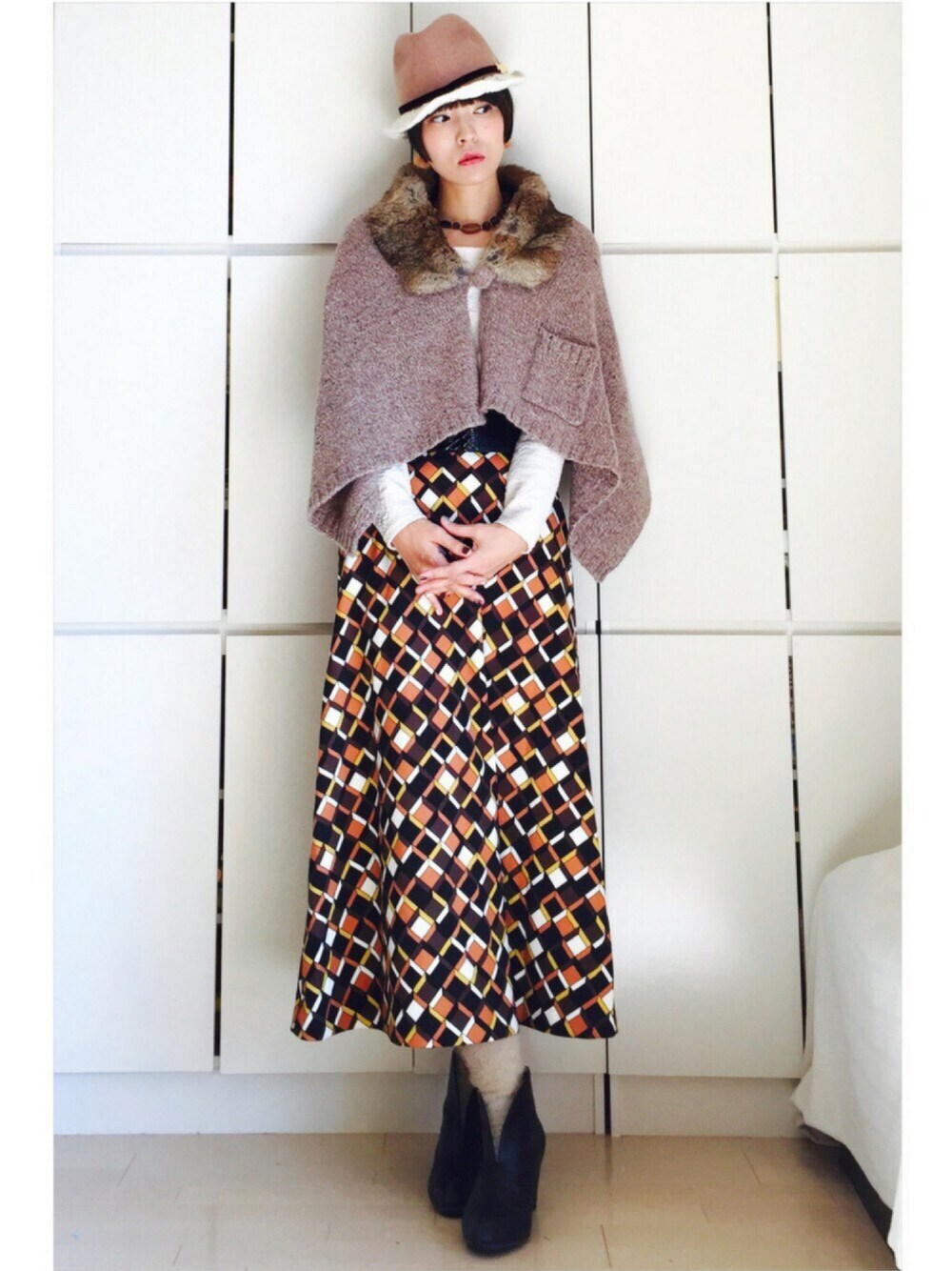 ブラウン系のスカート、ホワイト系のTシャツ/カットソー、ブラウン系のストール/ショールを着用したレディースの秋コーディネートの1枚目の写真