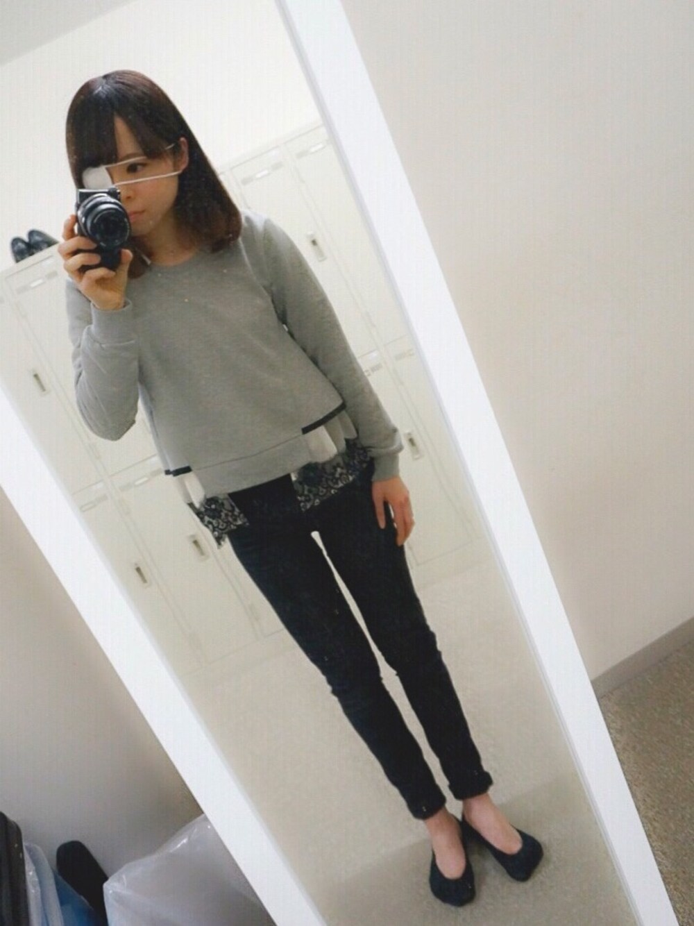 グレー系のスウェット、ブラック系のデニムパンツ、ブルー系のシューズを着用したレディースの春コーディネートの1枚目の写真