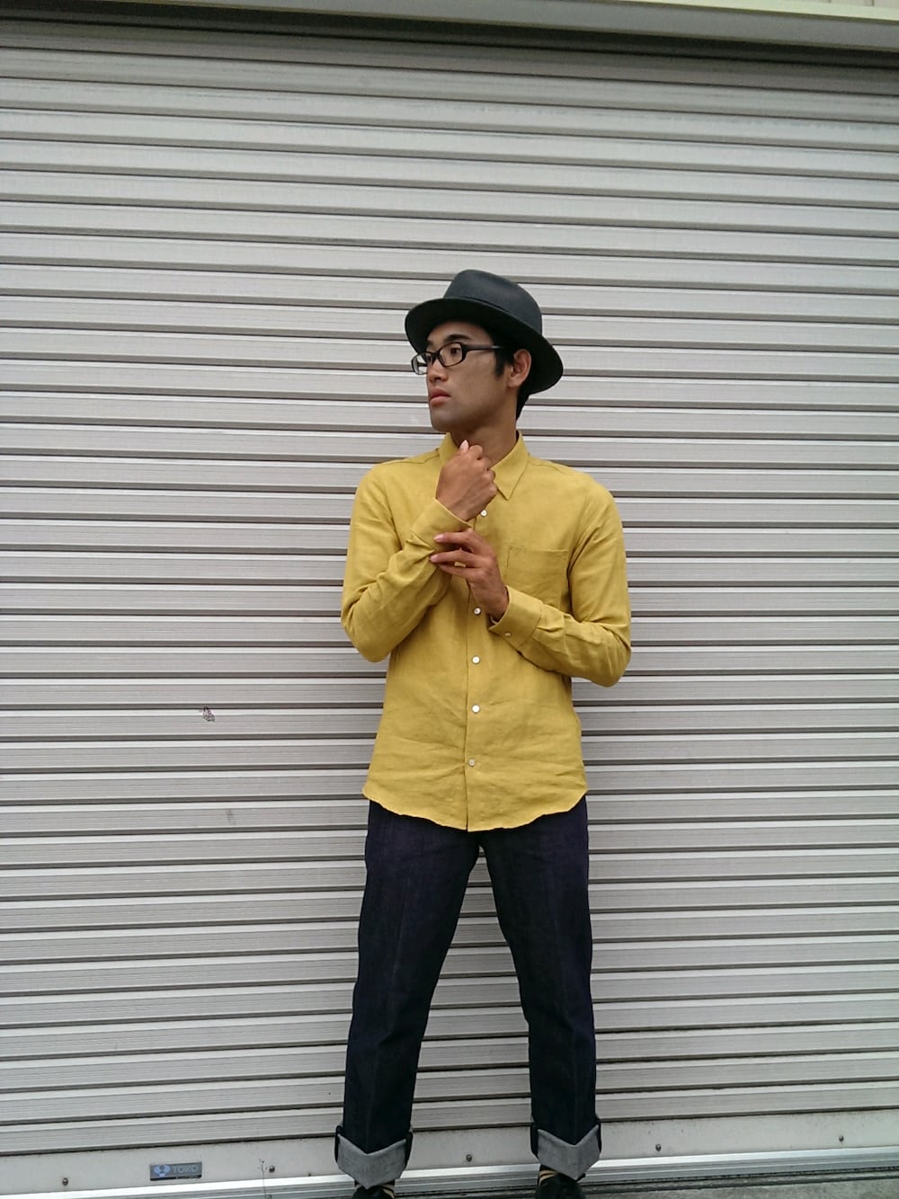 イエロー系のトップス、その他のパンツ、グレー系の帽子を着用したメンズの夏コーディネートの1枚目の写真