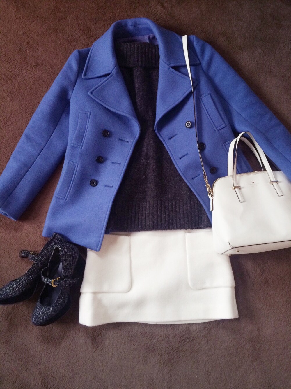 ブルー系のピーコート、ホワイト系のショルダーバッグ、ホワイト系のスカートを着用したレディースの秋コーディネートの1枚目の写真