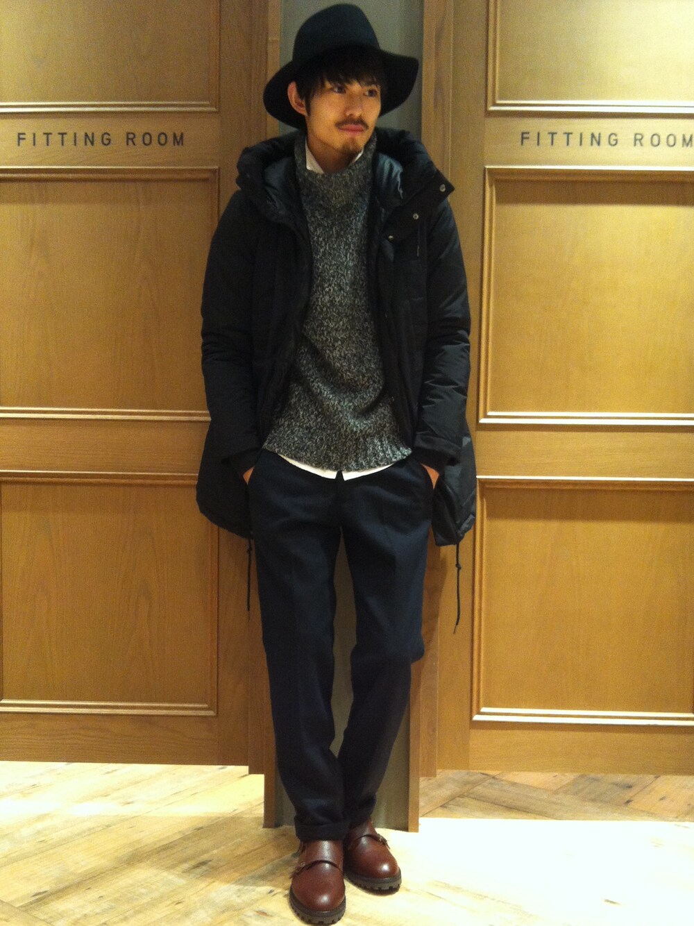 ブラック系のダウンジャケット/コート、ブラック系のニット/セーター、ホワイト系のシャツ/ブラウスを着用したメンズの冬コーディネートの1枚目の写真