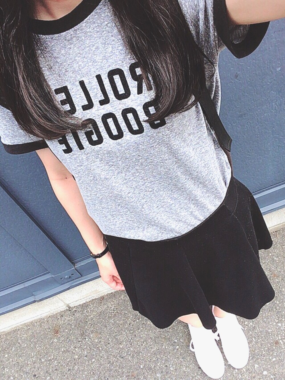 グレー系のTシャツ/カットソー、ブラック系のスカート、ホワイト系のスニーカーを着用したレディースの夏コーディネートの1枚目の写真