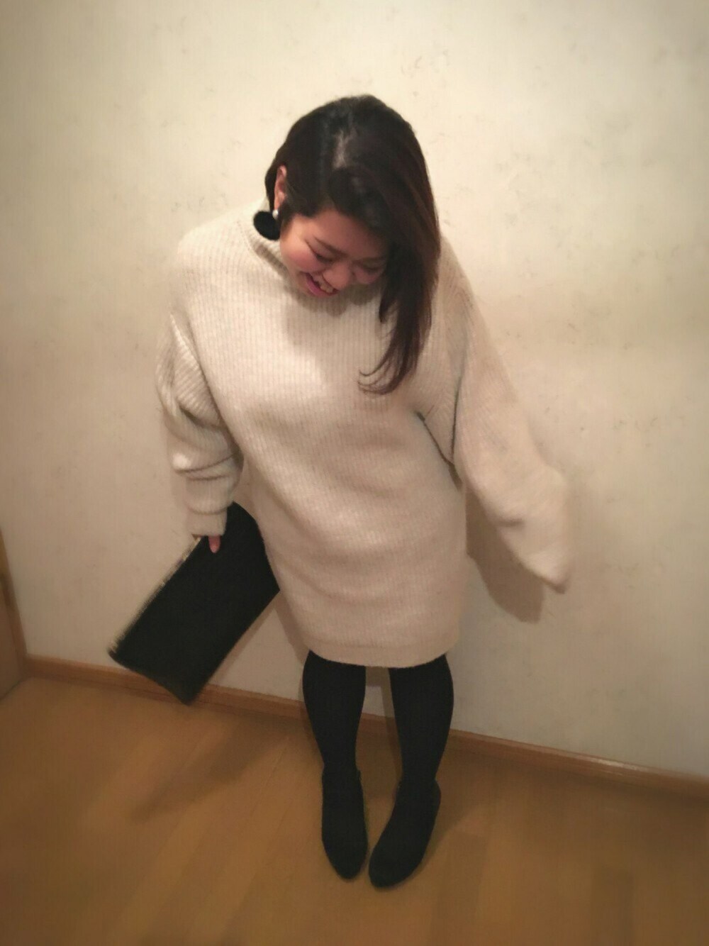 ホワイト系のワンピース、ブラック系のクラッチバッグ、ブラック系のブーティを着用したレディースの秋コーディネートの1枚目の写真