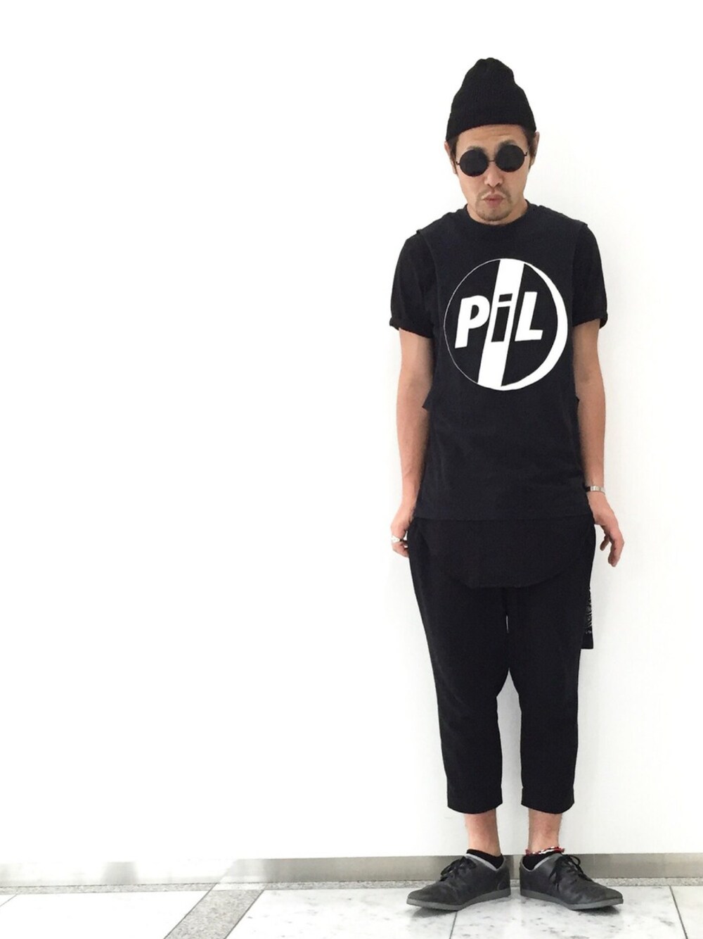 グレー系のスニーカー、ブラック系のTシャツ/カットソー、ブラック系のTシャツ/カットソーを着用したメンズの秋コーディネートの1枚目の写真