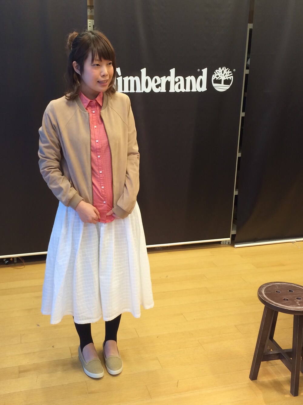 ベージュ系のライダースジャケット、レッド系のシャツ/ブラウス、ベージュ系のスニーカーを着用したレディースの春コーディネートの1枚目の写真