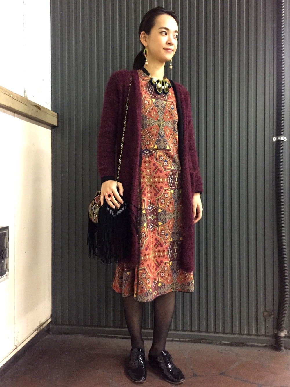 「秋コーデ、ZARA、柄ワンピース、axes femme、ロングカーディガン、エンジ色、フリンジバッグ、エスニック、objetsayoko、ﾊﾝﾄﾞﾒｲﾄﾞｱｸｾｻﾘｰ」｜「axes femmeの透かし編みフェザーロングカーデ（カーディガン/ボレロ、レッド系）」を使った、菅千代美(すがちよみ)さん（レディース・170cm）の秋コーディネートの1枚目の写真