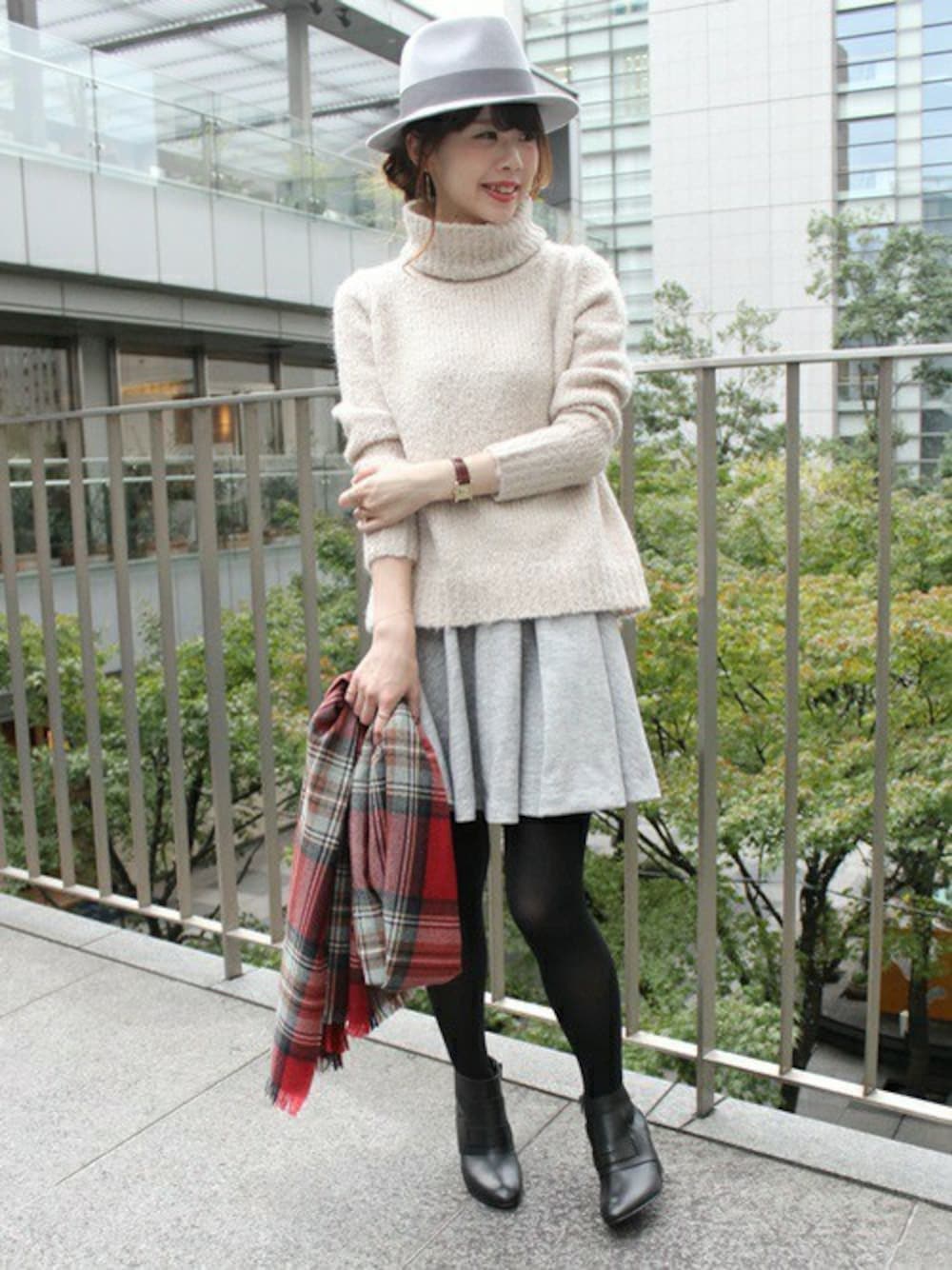 ベージュ系のニット/セーター、グレー系のスカート、ブラック系のブーツを着用したレディースの秋コーディネートの1枚目の写真