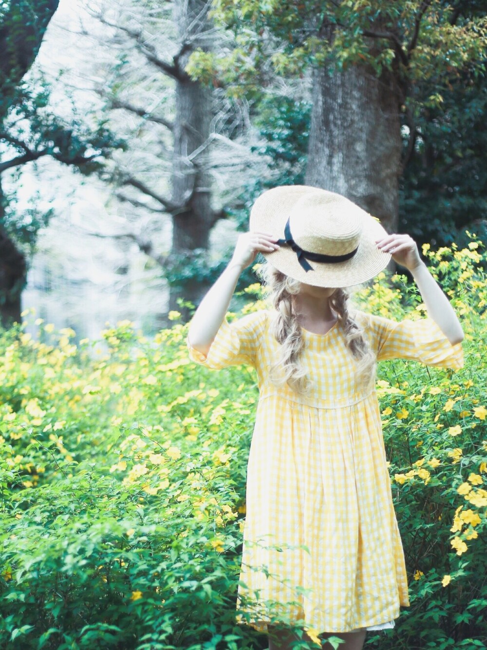 イエロー系のワンピース、イエロー系のその他、ベージュ系のハットを着用したレディースの春コーディネートの1枚目の写真