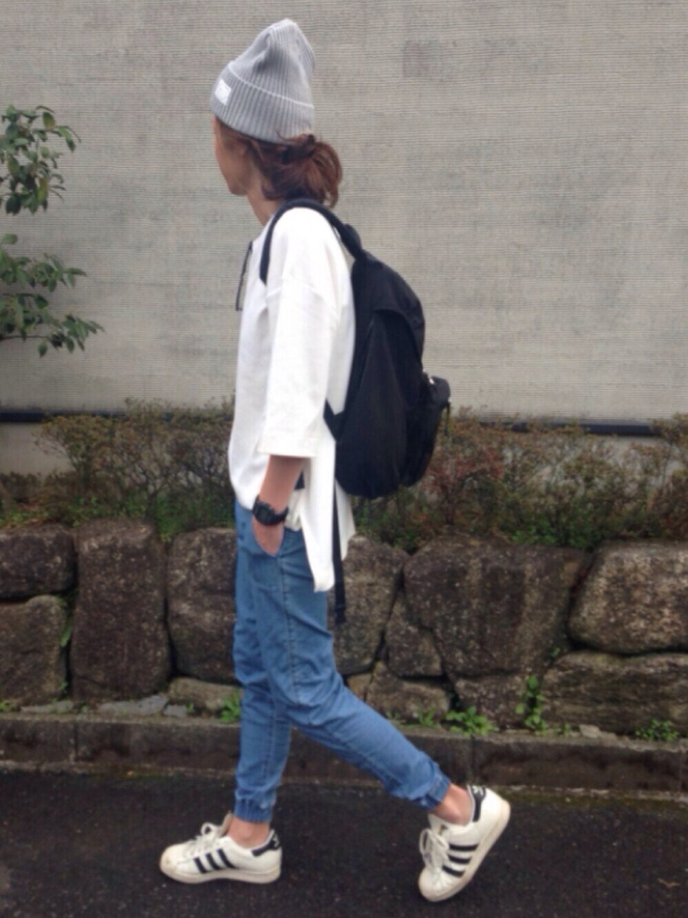 ホワイト系のTシャツ/カットソー、ブルー系のデニムパンツ、ブラック系のバックパック/リュックを着用したレディースの春コーディネートの1枚目の写真