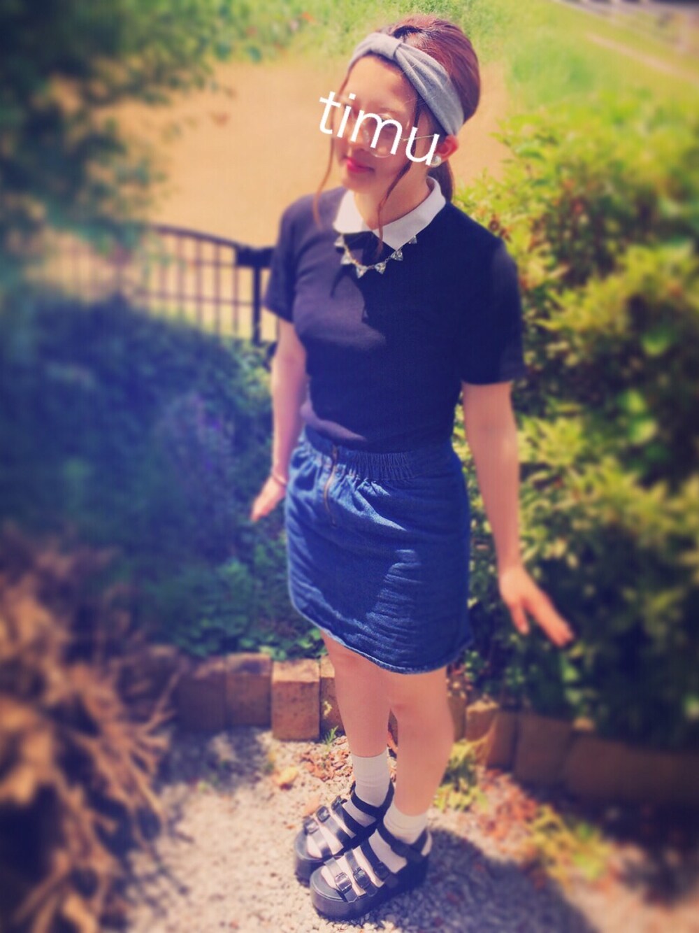 ブラック系のポロシャツ、ブラック系のデニムスカート、ブラック系のサンダルを着用したレディースの夏コーディネートの1枚目の写真