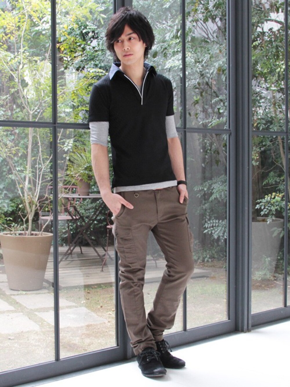 グリーン系のその他パンツ、ブラック系のその他シューズ、ブラック系のポロシャツを着用したメンズの春コーディネートの1枚目の写真