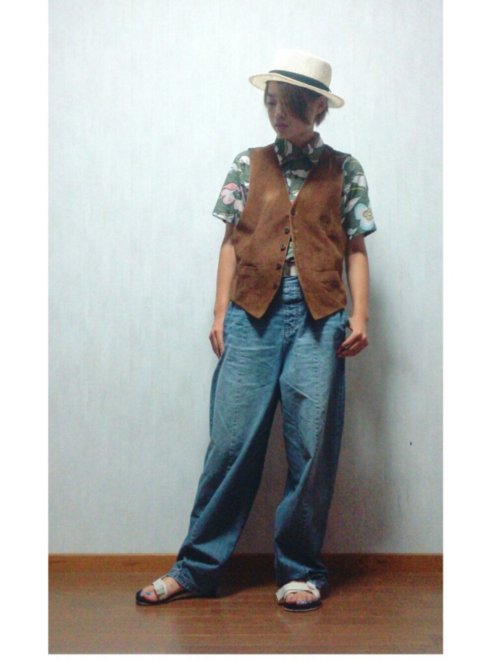 ブラウン系のベスト、ホワイト系のサンダルを着用したレディースの秋コーディネートの1枚目の写真