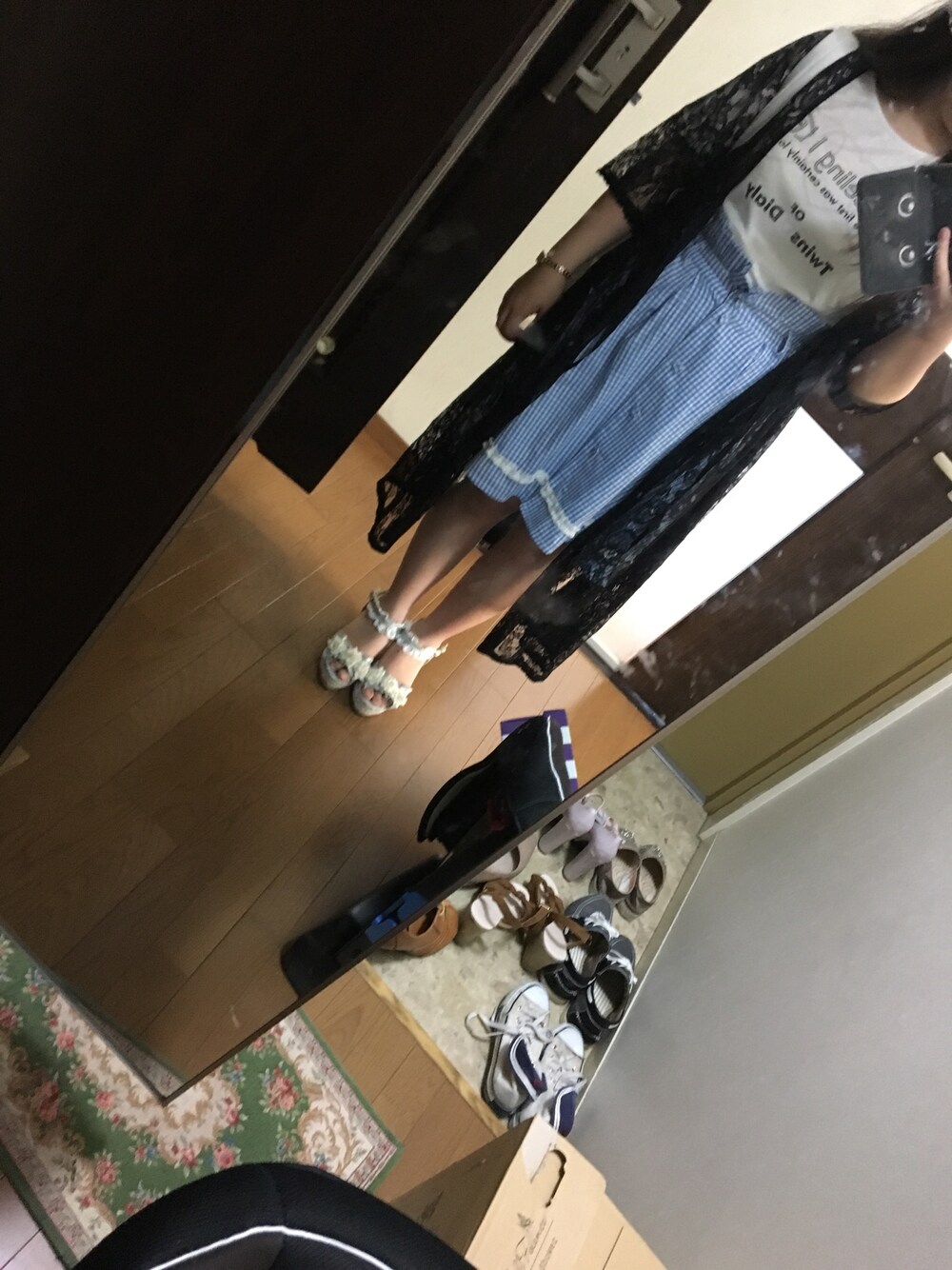 ブルー系のサンダル、ブラック系のトップス、ホワイト系のTシャツ/カットソーを着用したレディースの夏コーディネートの1枚目の写真