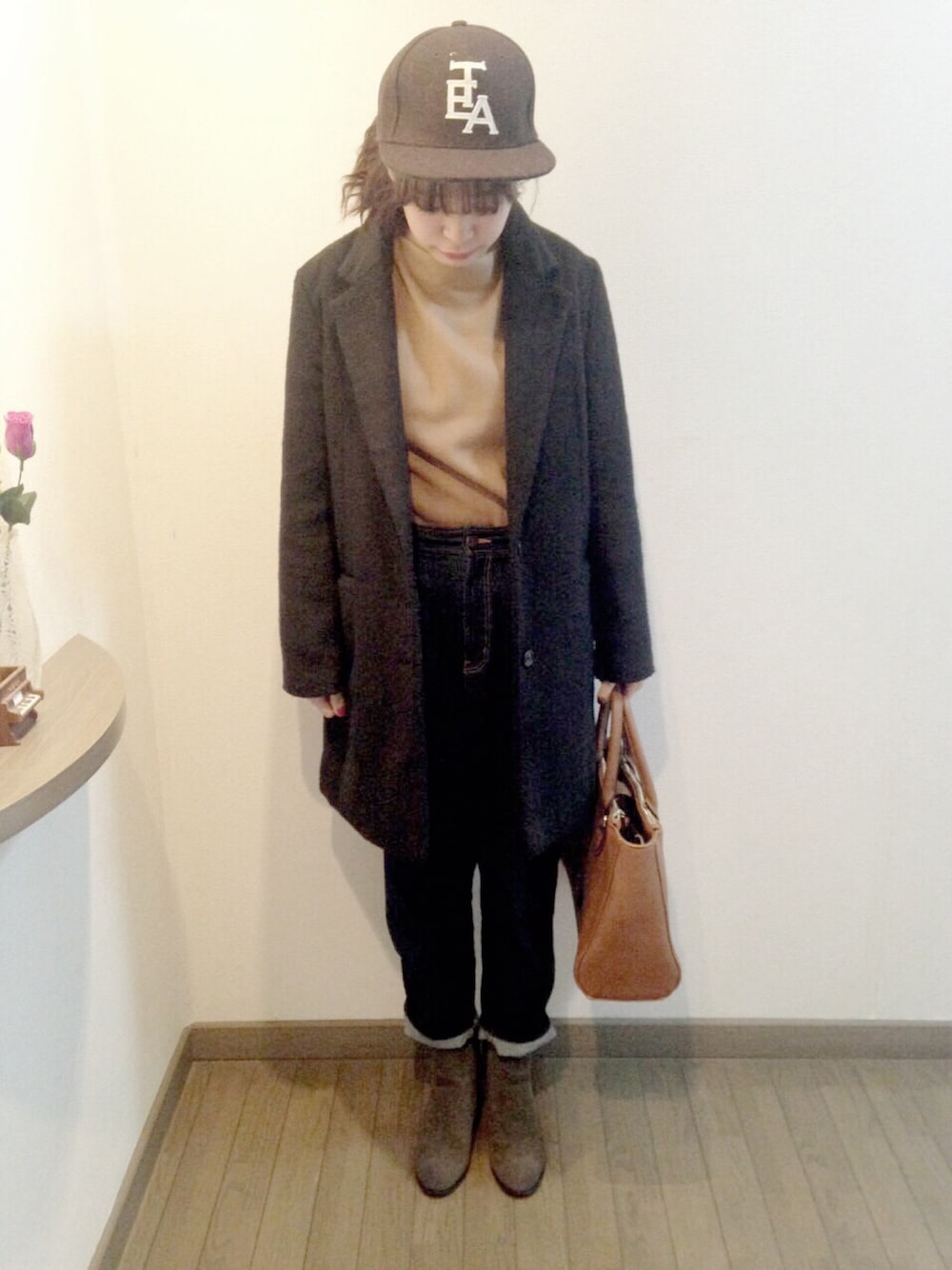 ベージュ系のニット/セーター、ブラック系のチェスターコート、その他のデニムパンツを着用したレディースの冬コーディネートの1枚目の写真
