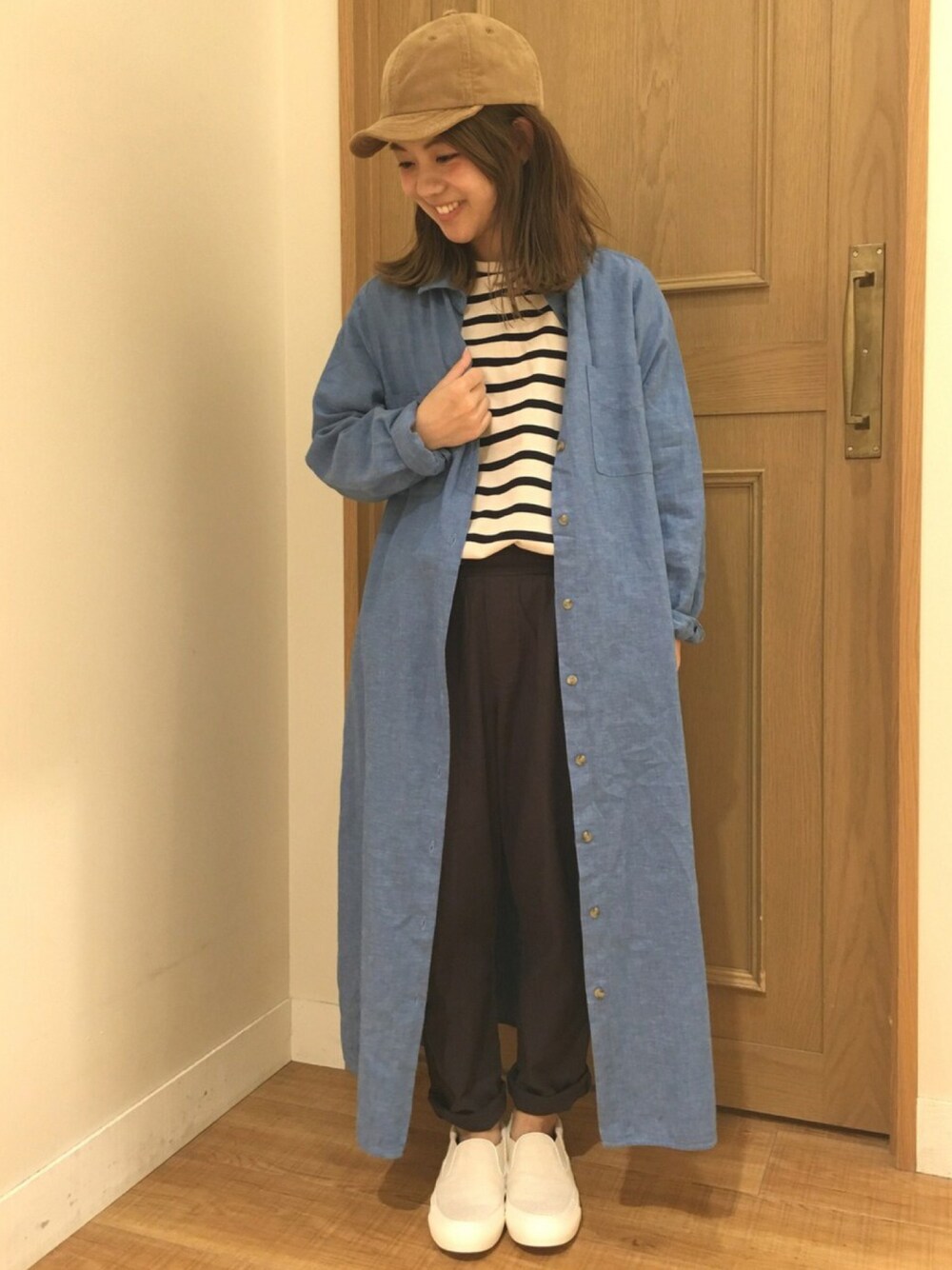 ブルー系のシャツワンピース、グレー系のパンツ、ホワイト系のスリッポンを着用したレディースの夏コーディネートの1枚目の写真