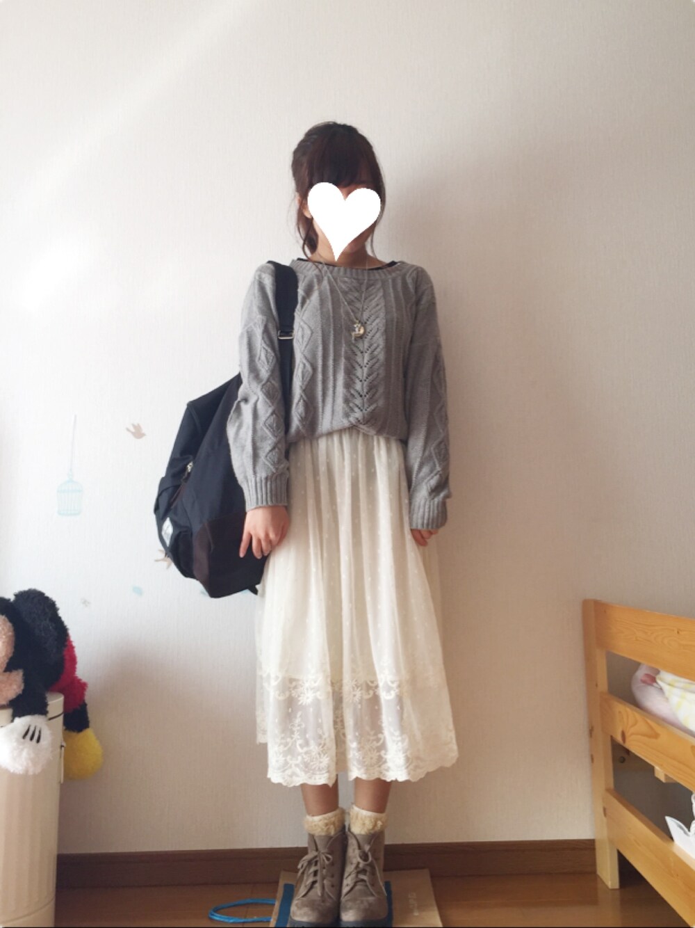 グレー系のニット/セーター、ブラウン系のブーツ、ブラック系のバックパック/リュックを着用したレディースの秋コーディネートの1枚目の写真