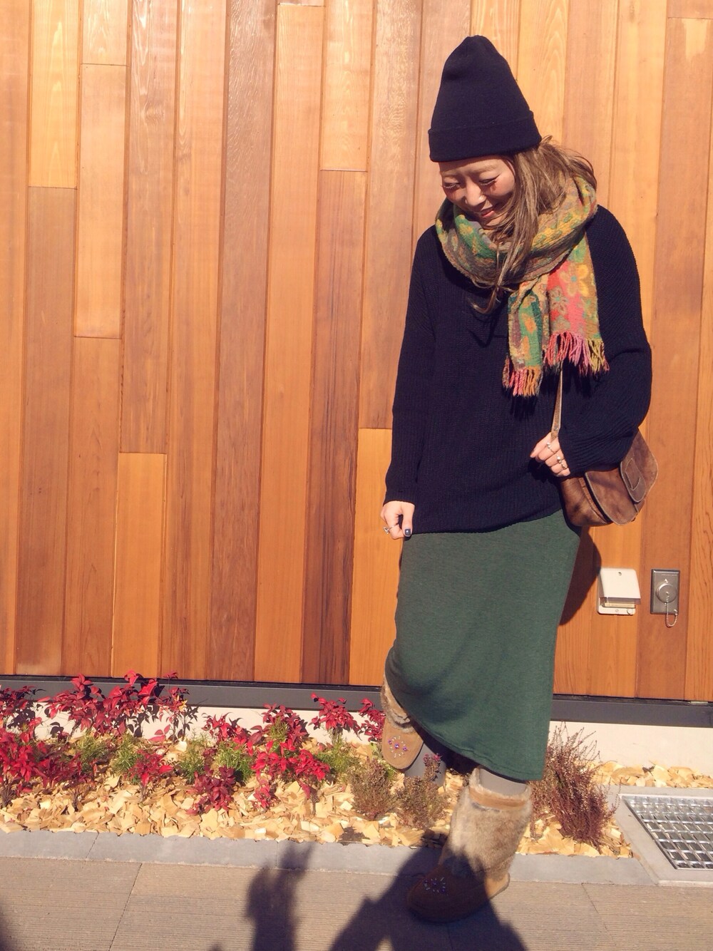 ブラウン系のショルダーバッグ、ブラウン系のブーツ、その他のマフラーを着用したレディースの冬コーディネートの1枚目の写真