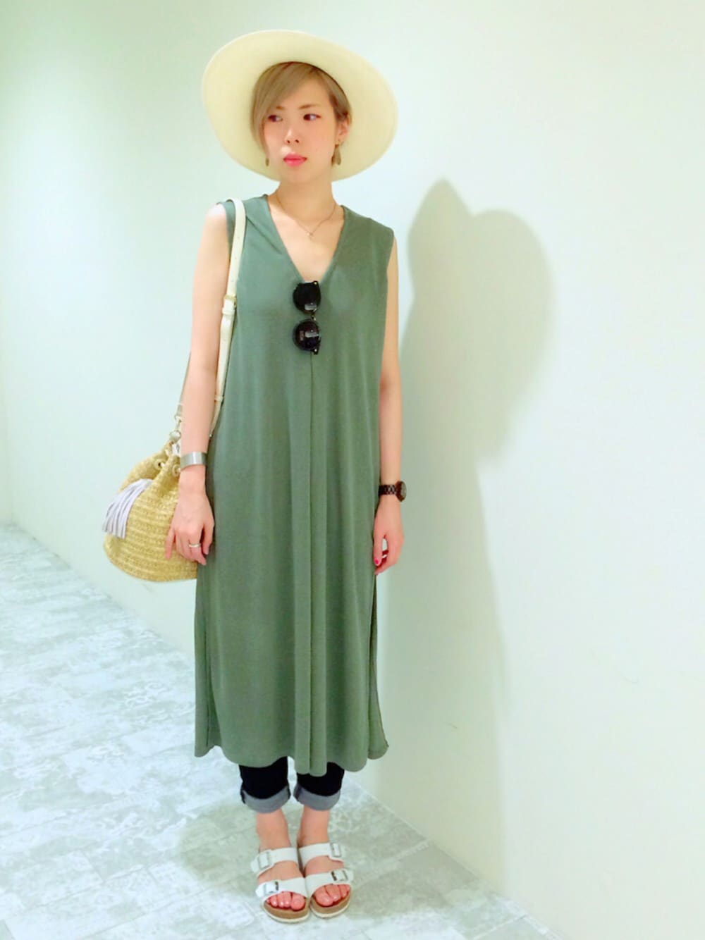 ホワイト系のサンダル、ブルー系のデニムパンツ、グリーン系のワンピースを着用したレディースの夏コーディネートの1枚目の写真
