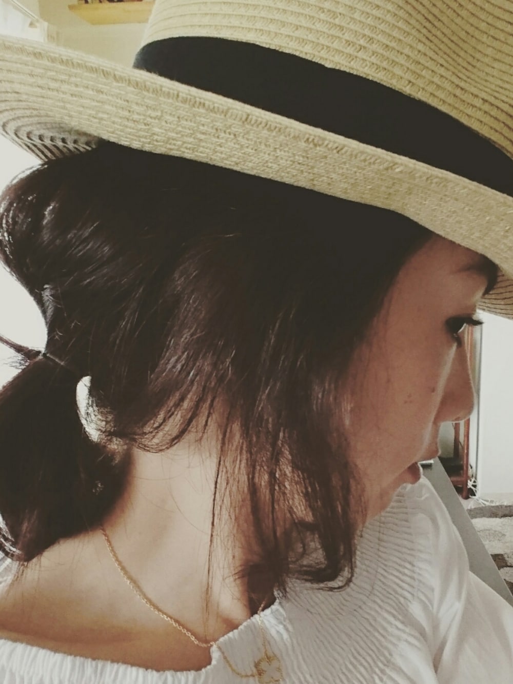 ホワイト系のネックレス、ベージュ系のハットを着用したレディースの夏コーディネートの1枚目の写真