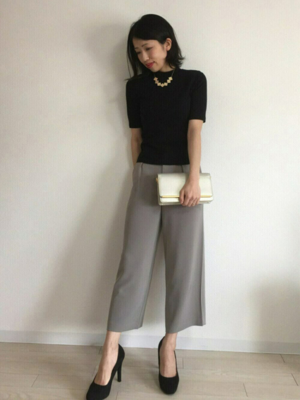 ブラック系のTシャツ/カットソー、グレー系のパンツ、ブラック系のパンプスを着用したレディースの冬コーディネートの1枚目の写真