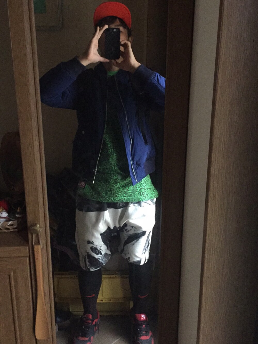 ブラック系のTシャツ/カットソー、ブルー系のミリタリージャケット、ホワイト系のパンツを着用したメンズの秋コーディネートの1枚目の写真