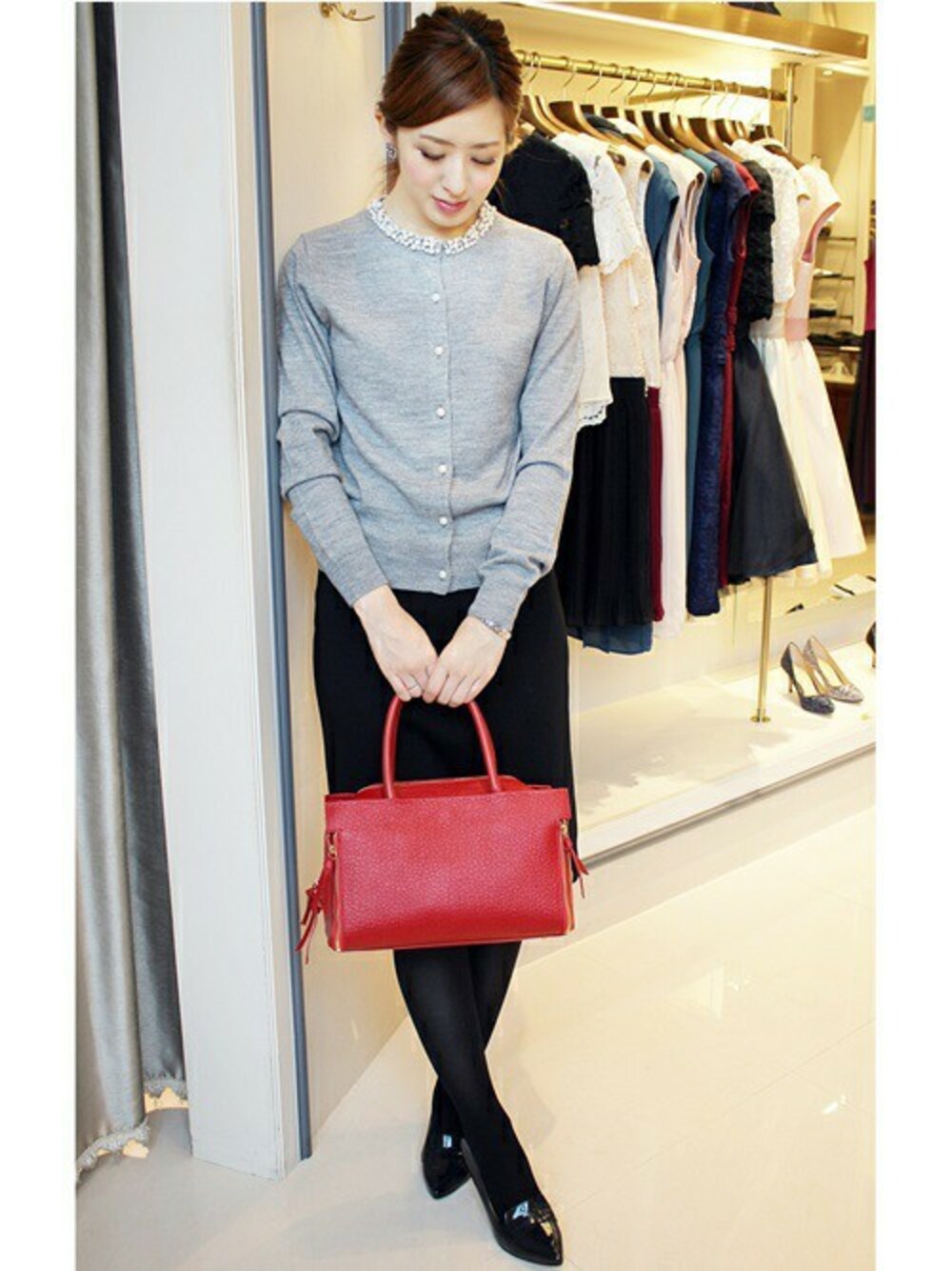 グレー系のカーディガン/ボレロ、ブラック系のスカート、ブルー系のパンプスを着用したレディースの秋コーディネートの1枚目の写真