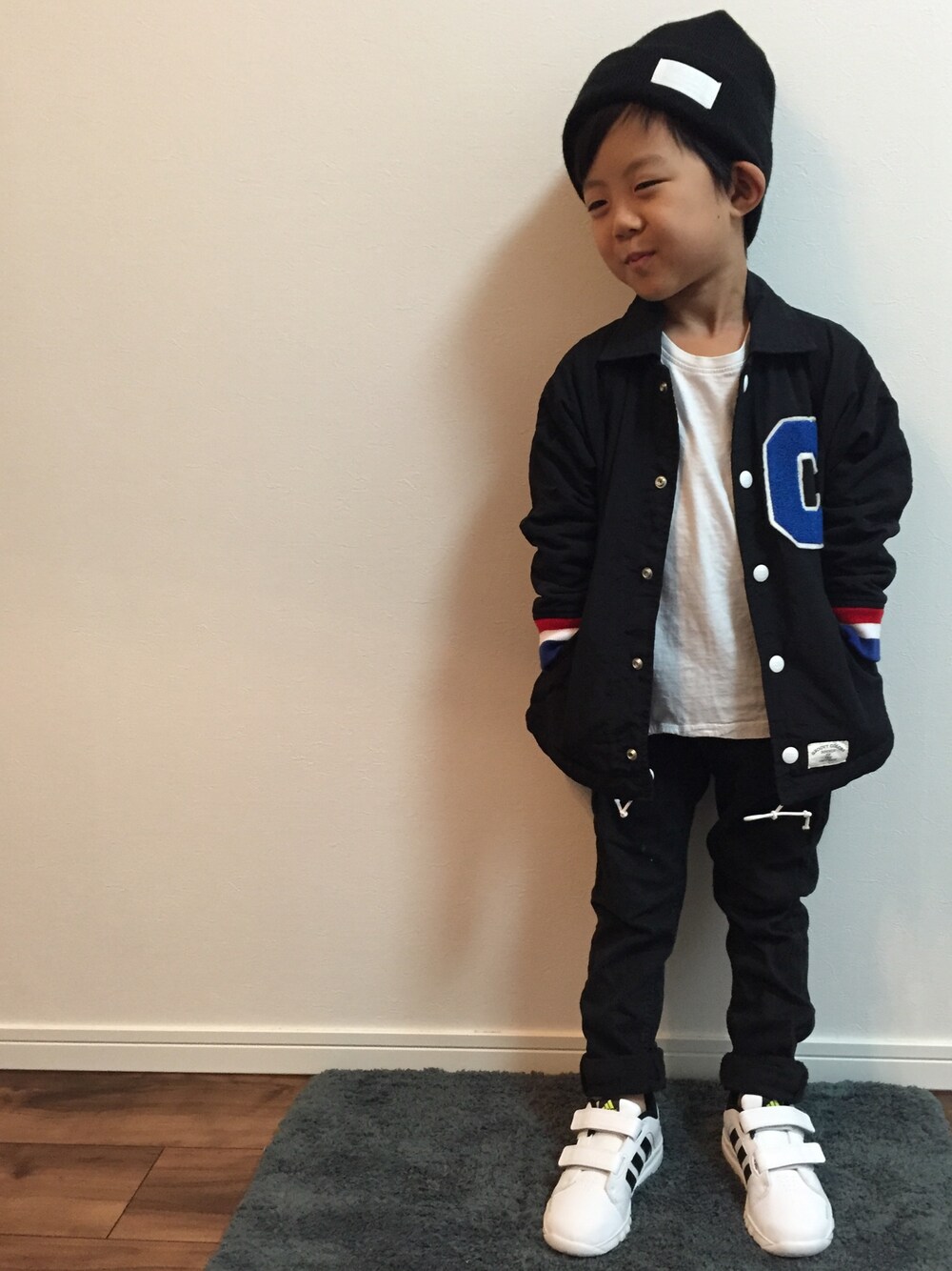 ホワイト系のスニーカー、ブラック系のナイロンジャケット、ブラック系のその他パンツを着用したキッズの秋コーディネートの1枚目の写真