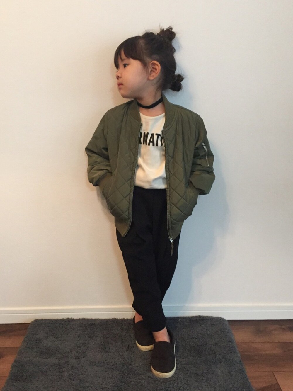 ブラック系のスリッポン、グリーン系のその他アウター、ホワイト系のTシャツ/カットソーを着用したキッズの冬コーディネートの1枚目の写真