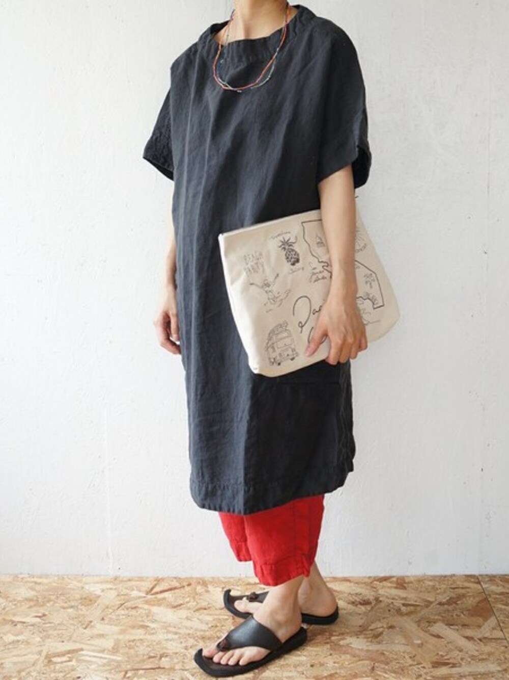 グレー系のワンピース、レッド系のその他パンツ、ホワイト系のクラッチバッグを着用したレディースの夏コーディネートの1枚目の写真