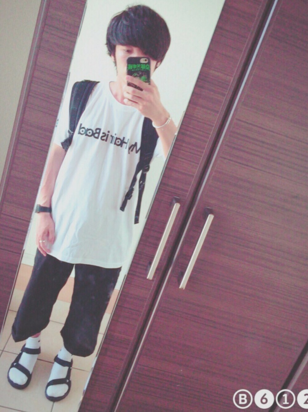 ホワイト系のTシャツ/カットソー、ブラック系のバックパック/リュック、ブラック系のサンダルを着用したメンズの夏コーディネートの1枚目の写真