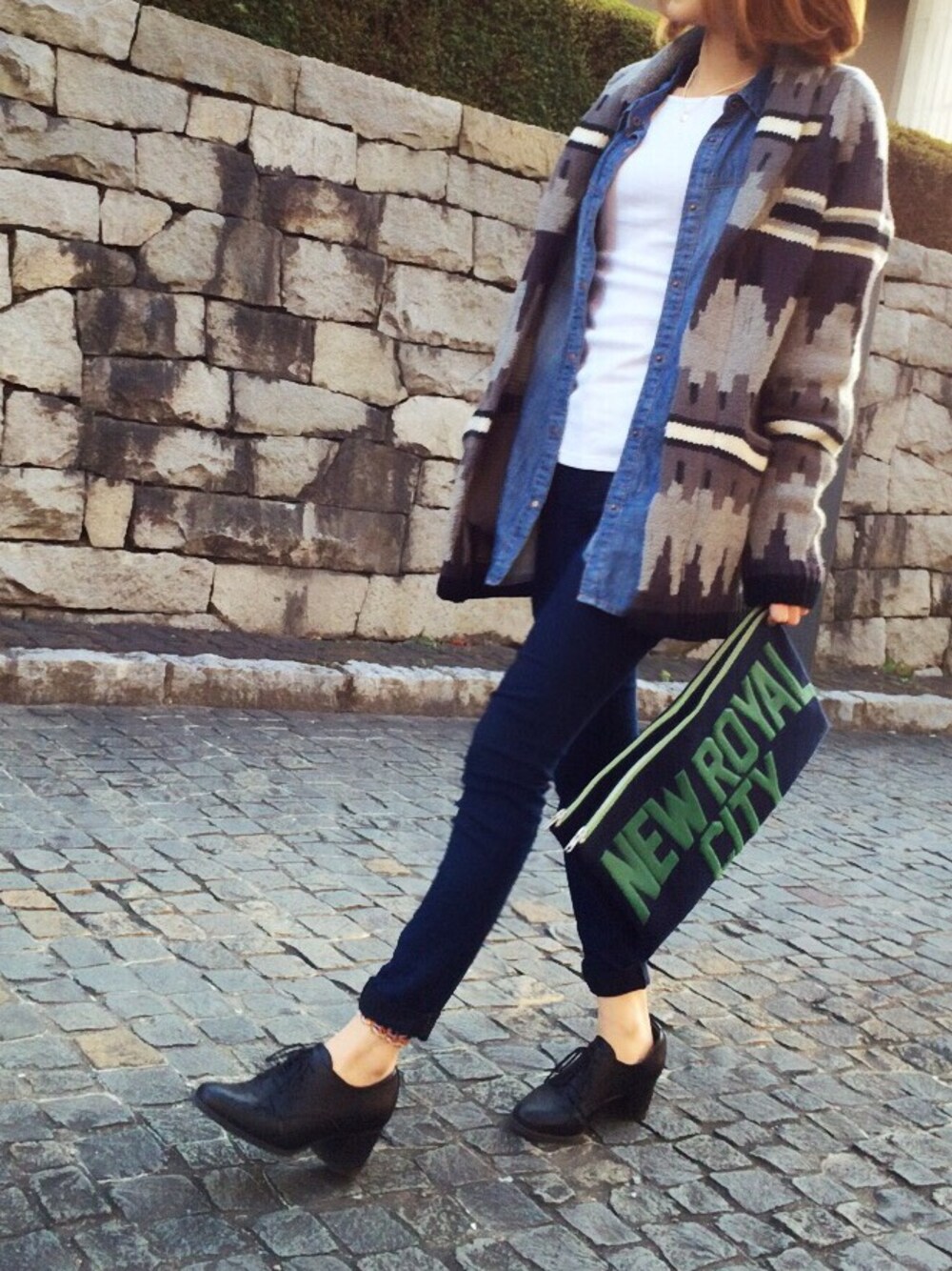 ブルー系のデニムパンツ、グレー系のカーディガン/ボレロ、ブルー系のクラッチバッグを着用したレディースの冬コーディネートの1枚目の写真