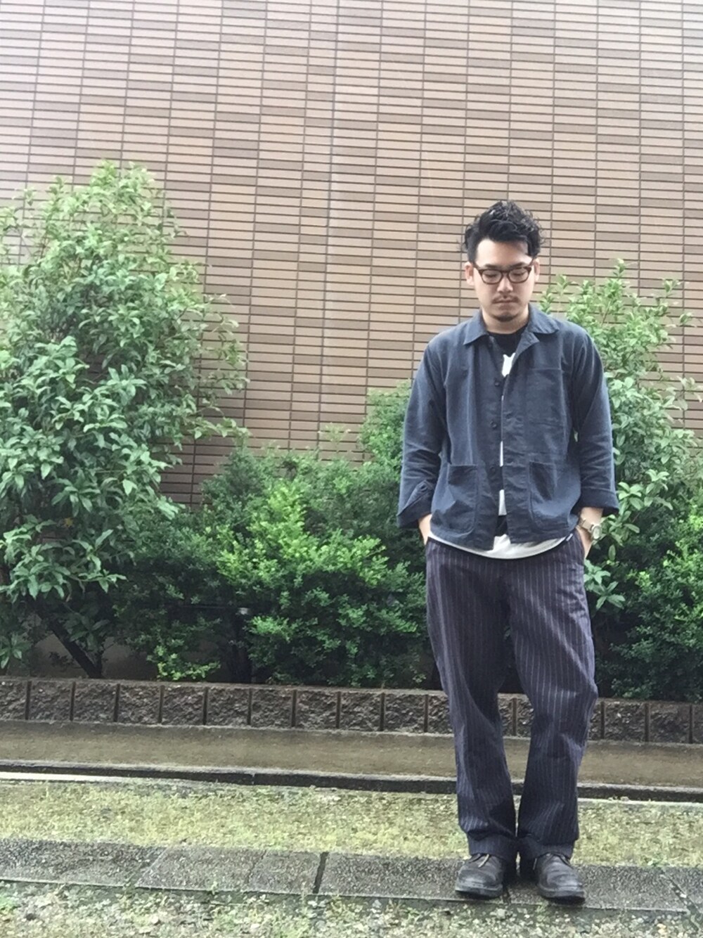 ブルー系のカバーオール、ブラック系のTシャツ/カットソー、ブルー系のスラックスを着用したメンズの夏コーディネートの1枚目の写真