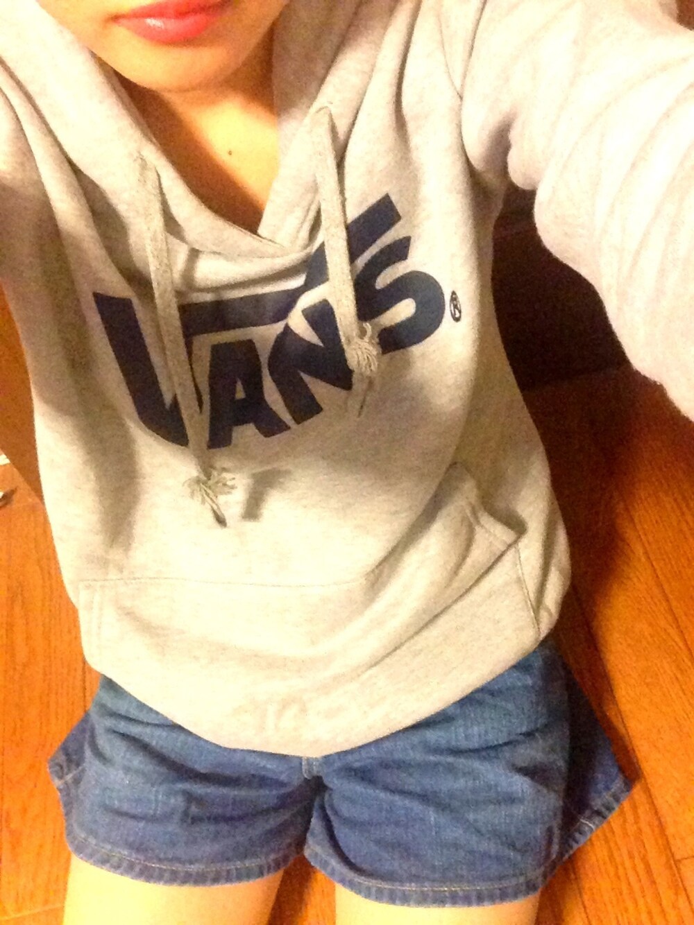 グレー系のパーカー、ブルー系のデニムパンツを着用したレディースの秋コーディネートの1枚目の写真