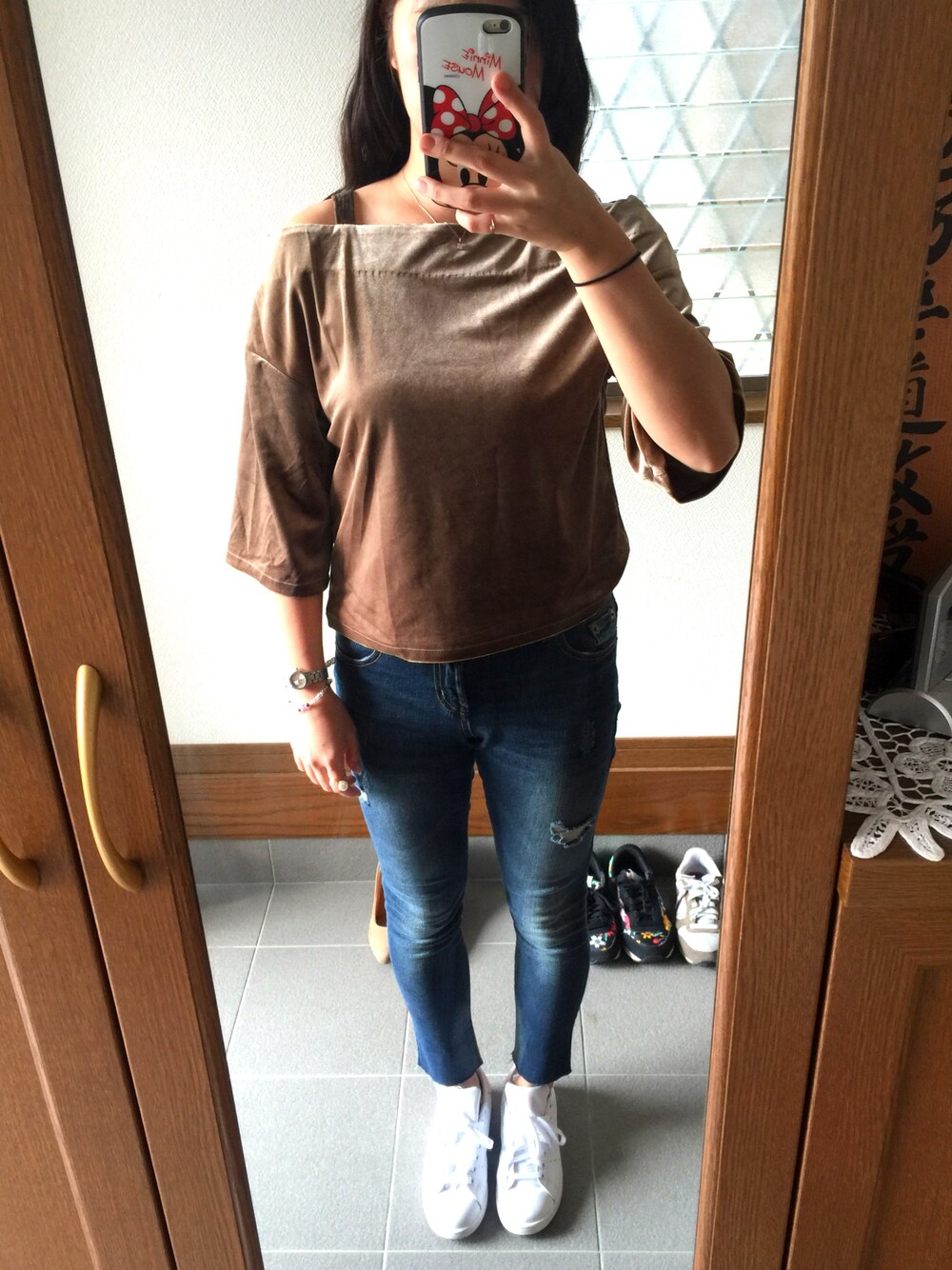 ホワイト系のスニーカー、ブルー系のデニムパンツ、ブラウン系のその他トップスを着用したレディースの秋コーディネートの1枚目の写真