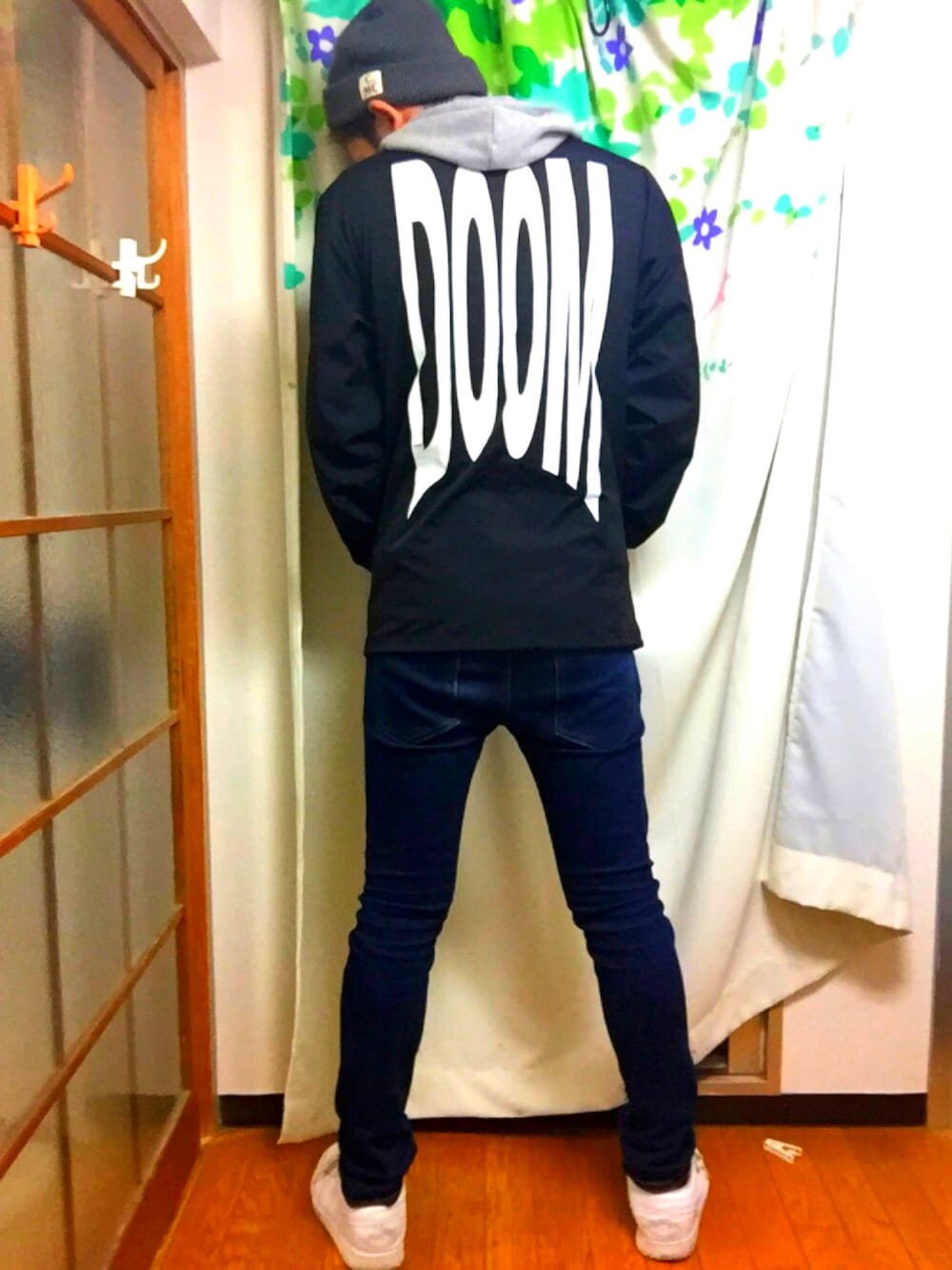 ブラック系のナイロンジャケット、グレー系のパーカー、ブルー系のデニムパンツを着用したメンズの秋コーディネートの1枚目の写真