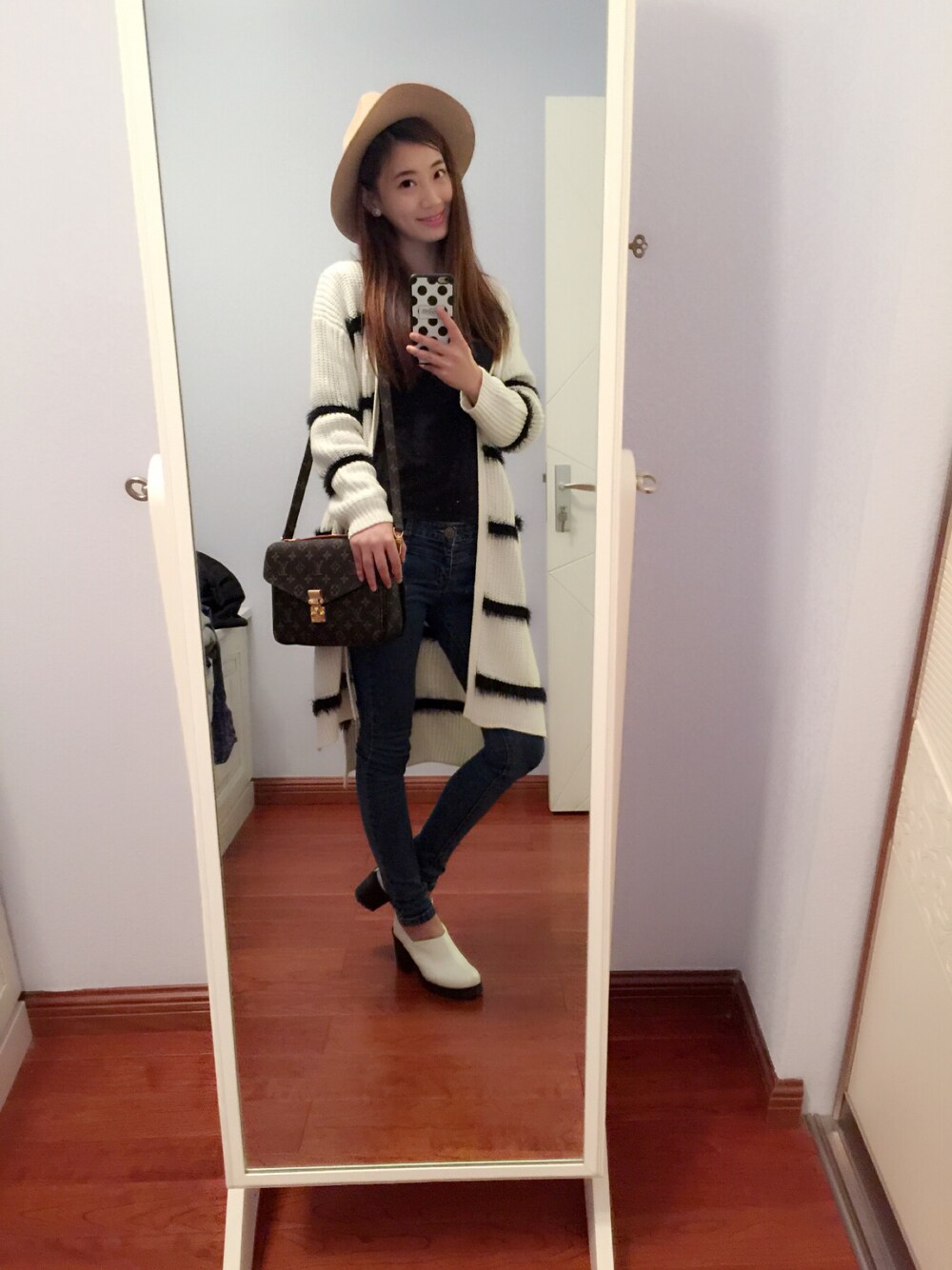 ホワイト系のカバーオール、ブラウン系のハンドバッグを着用したレディースの秋コーディネートの1枚目の写真