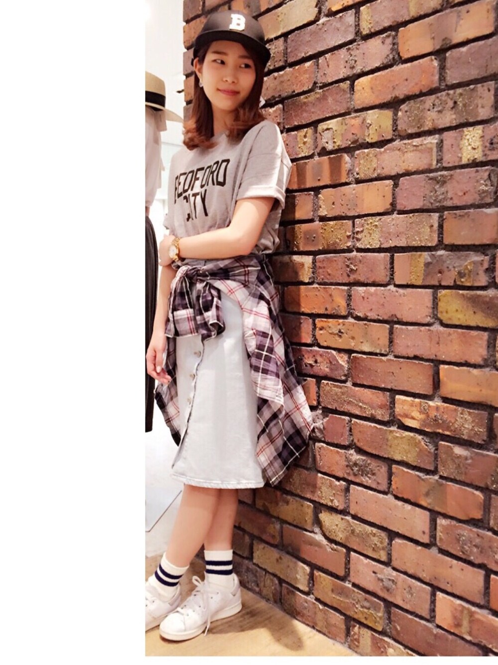 グレー系のシャツ/ブラウス、ブルー系のデニムスカート、ホワイト系のスニーカーを着用したレディースの夏コーディネートの1枚目の写真