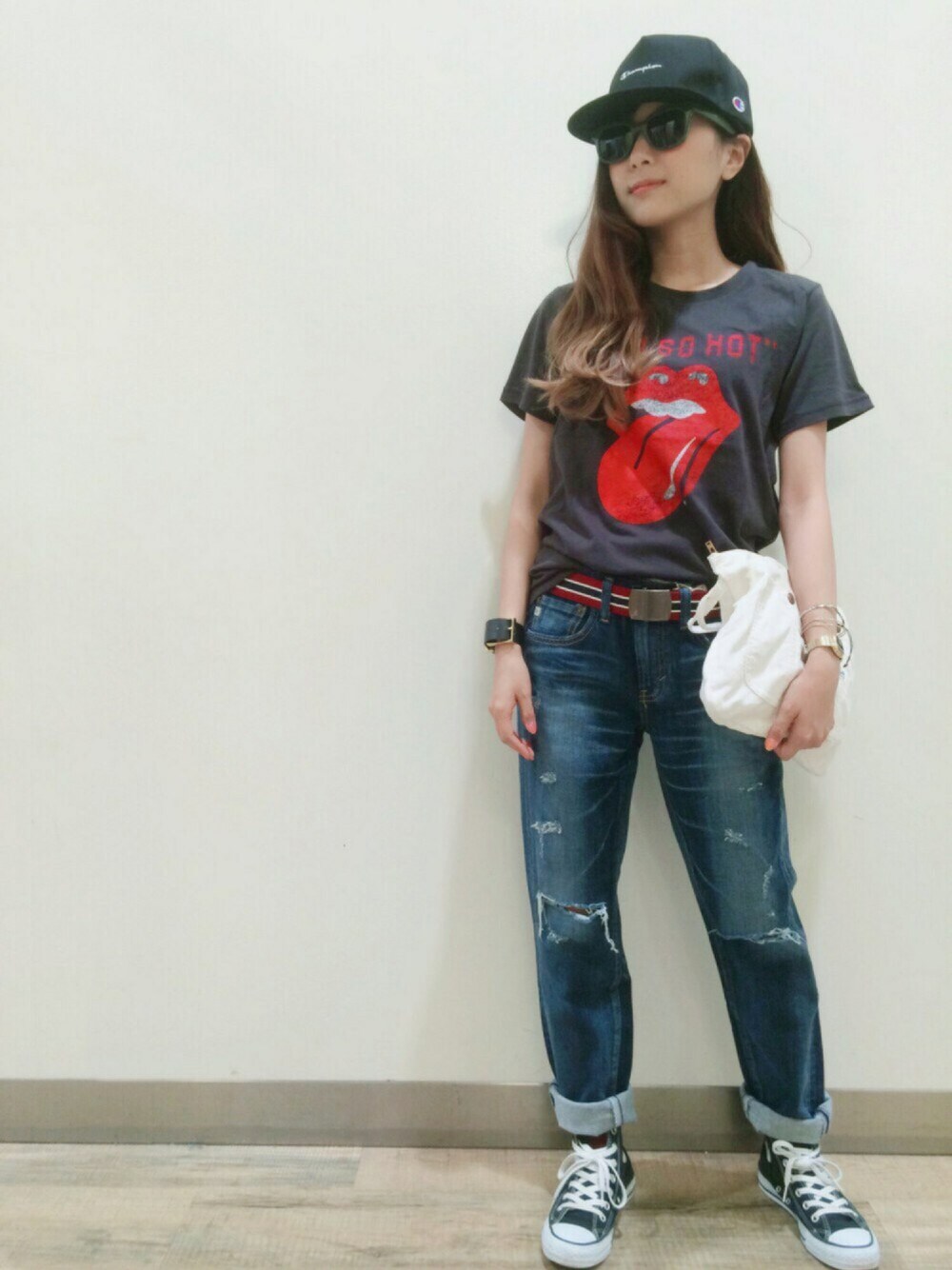 ブルー系のデニムパンツ、ブラック系のスニーカー、ホワイト系のクラッチバッグを着用したレディースの夏コーディネートの1枚目の写真