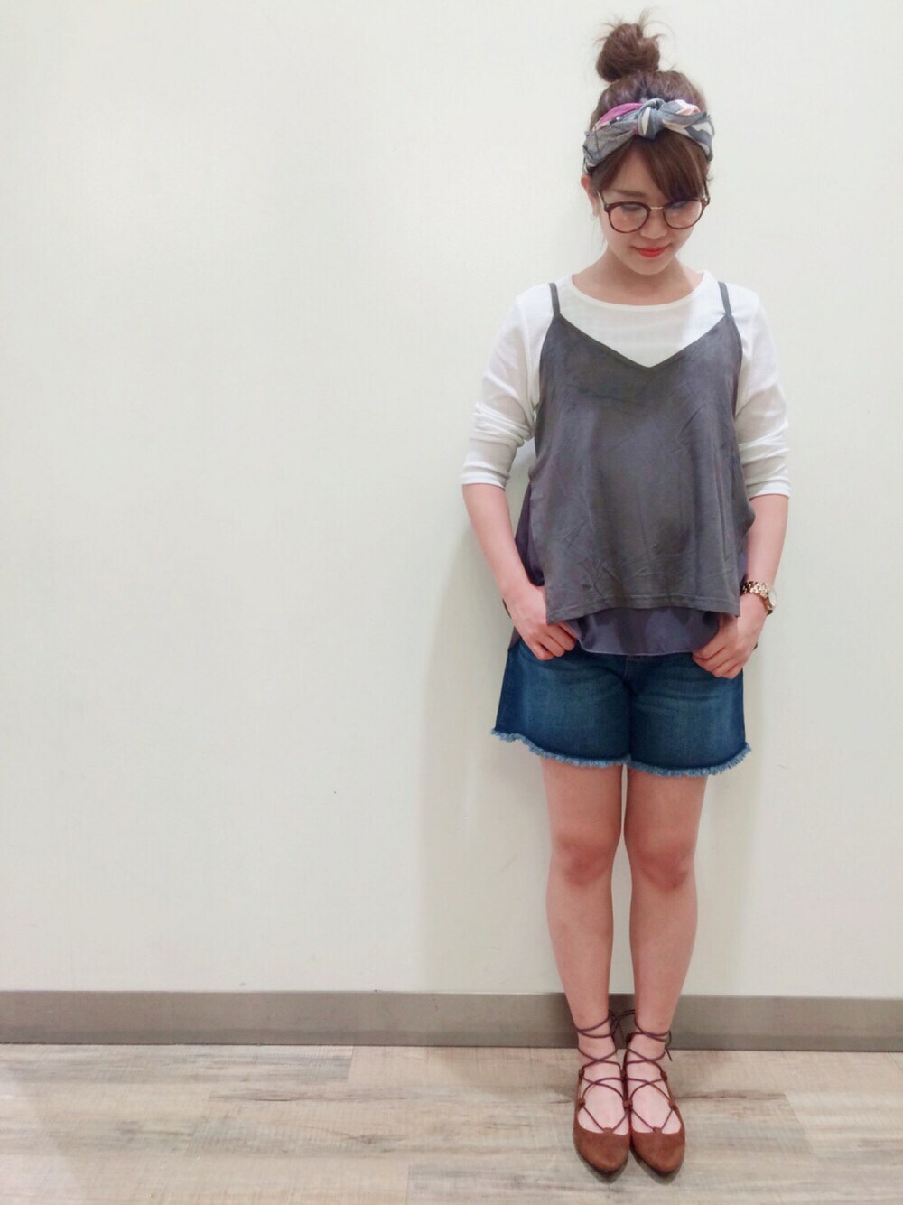 グレー系のトップス、ブルー系のデニムパンツ、イエロー系のパンプスを着用したレディースの夏コーディネートの1枚目の写真