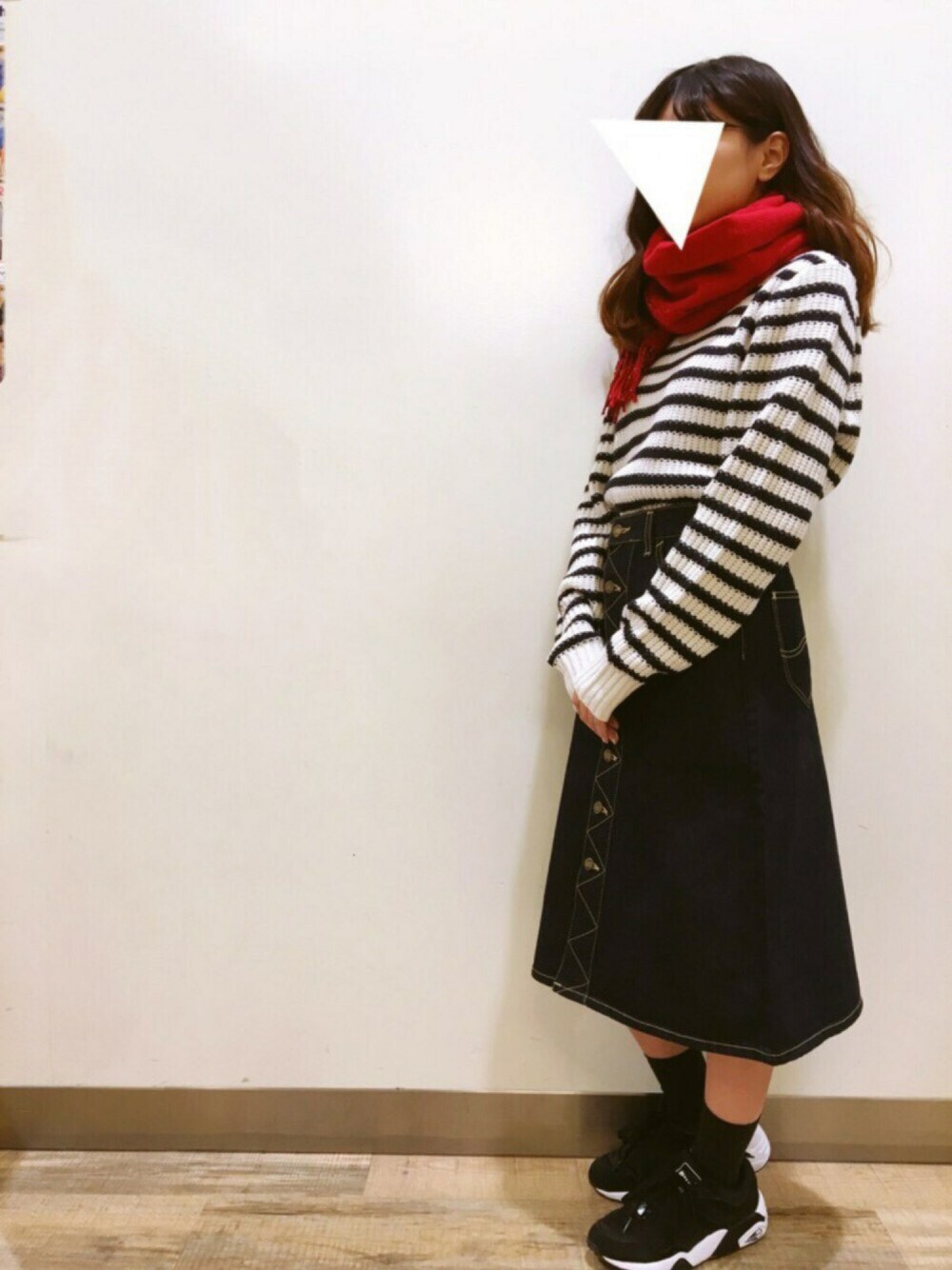 ホワイト系のニット/セーター、ブルー系のスカート、ブラック系のスニーカーを着用したレディースの冬コーディネートの1枚目の写真