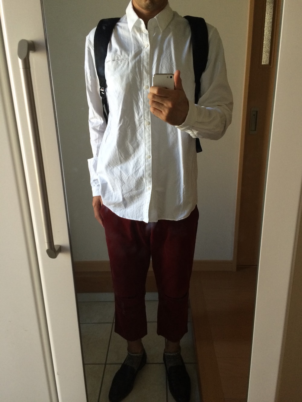 ホワイト系のシャツ/ブラウス、レッド系のその他パンツ、ブラック系のバックパック/リュックを着用したメンズの秋コーディネートの1枚目の写真